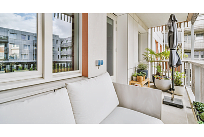 biała sofa balkonowa ustawiona na wąskim balkonie