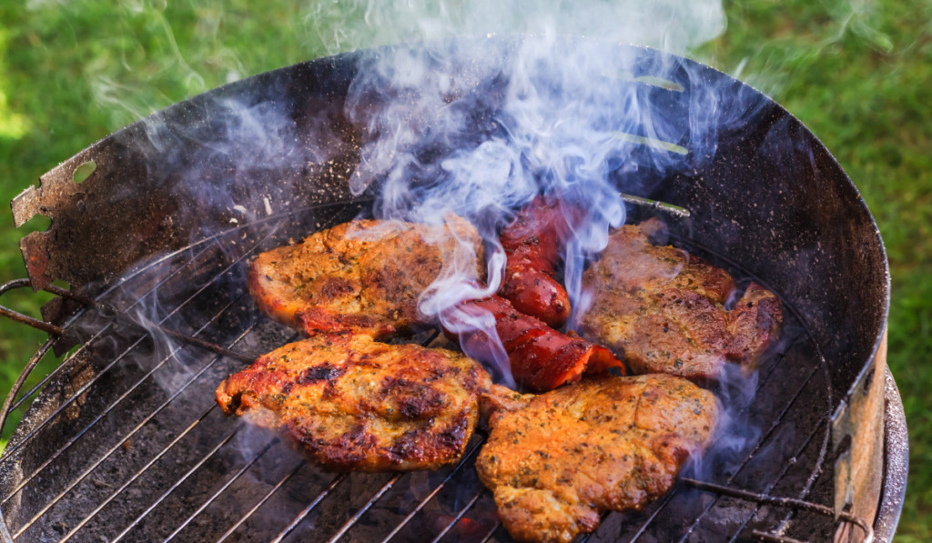 Kořeněné maso se griluje na zahradním grilu na dřevěné uhlí 