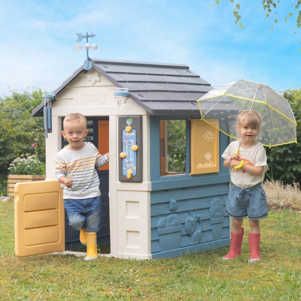Chłopiec i dziewczynka bawiące się na ogrodzie w domku dla dzieci 4 pory roku smoby