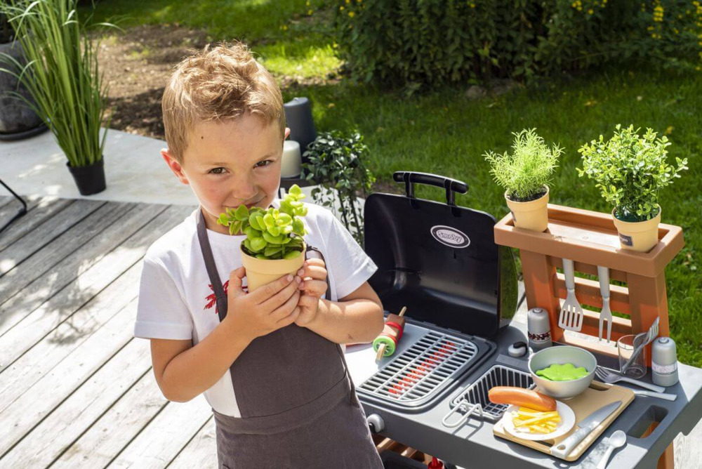 Chłopiec przed kuchnią ogrodową dla dzieci