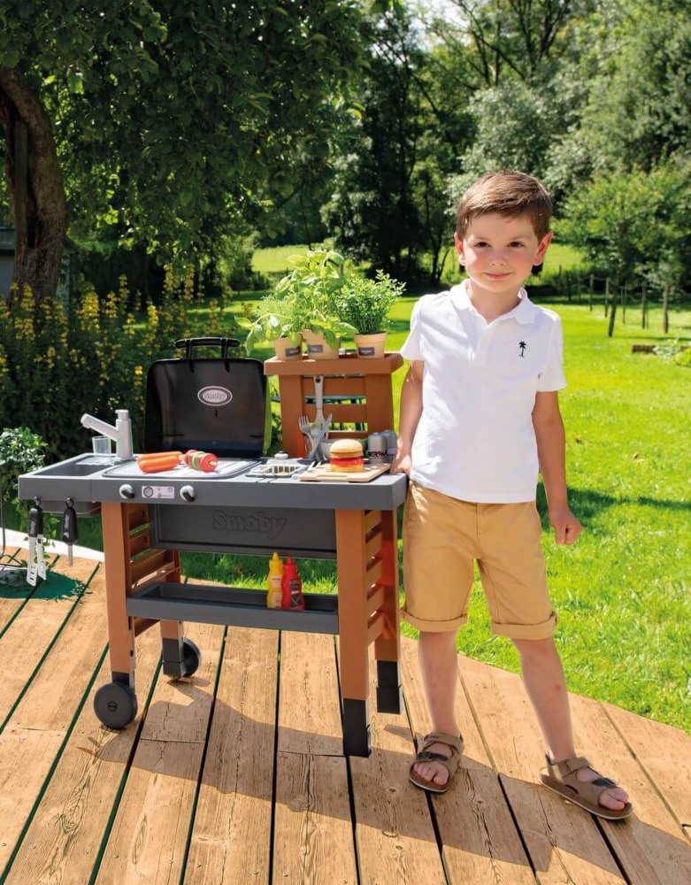 Chłopiec obok kuchni ogrodowej dla dzieci