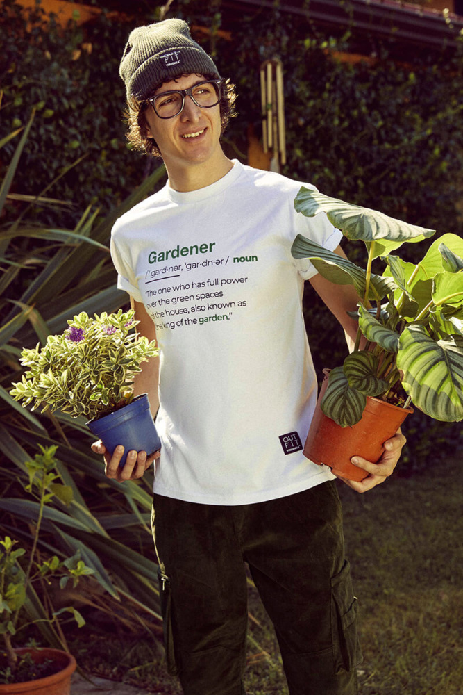 Mężczyzna ubrany w białą koszulkę z krótkimi rękawami gardener trzymający rośliny