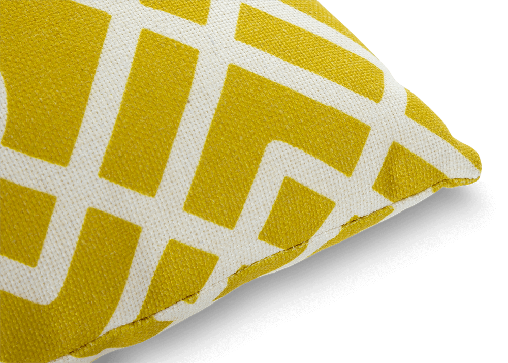 Zbliżenie na róg żółtej poduszki dekoracyjnej w białe wzory MoodMe Yellow Sunbrella
