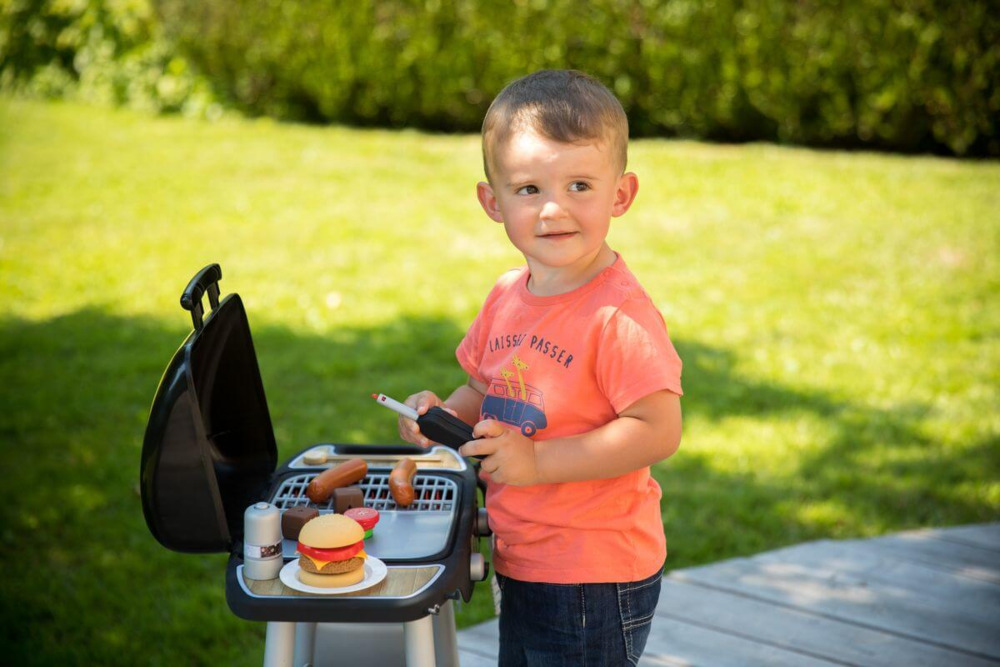 Chłopiec przy zestawie do grillowania dla dzieci smoby