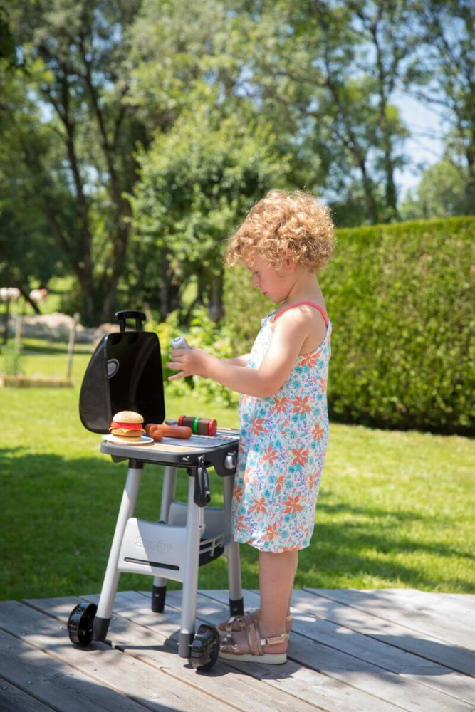 Dziewczynka przy zestawie do grillowania dla dzieci smoby