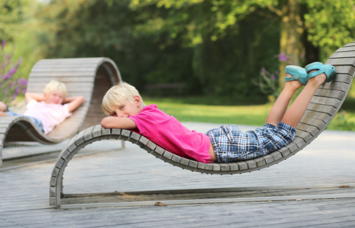 chłopiec odpoczywający z bratem na wygodnych ergonomicznych krzesłach ogrodowych 